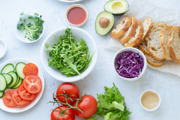 Top view flat lay with various vegetables and salad on concrete background.