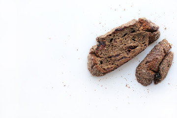 Pieces of homemade rye bread with cranberries on a white background with free space for text.