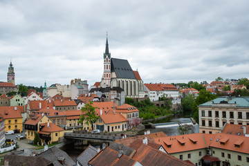 Panoramic landscape sunset view with blue dark sky from above to the historic city of Cesky Krumlov with famous Church city is on a UNESCO World Heritage Site captured during spring