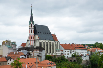 Fototapeta premium Panoramic landscape view of the historic city of Cesky Krumlov with famous Church city is on a UNESCO World Heritage Site captured during spring with nice sky and clouds