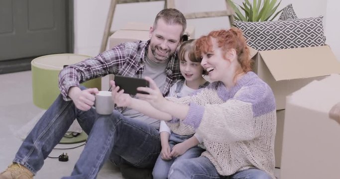 Family in new home on smart phone taking selfie