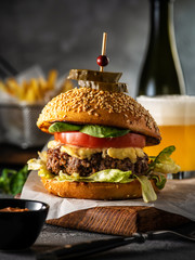 Big juicy delicious cheeseburger with beef, tomato, lettuce and pickles. Burger with beer and...