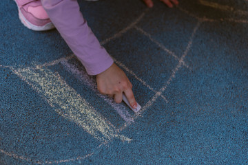 child draws with chalk on the street. Special coating for drawing on the playground.