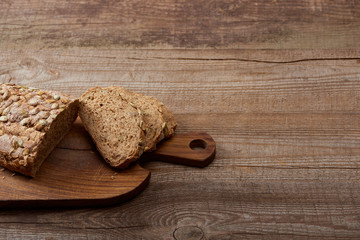 fresh cut bread loaf on chopping board on wooden table