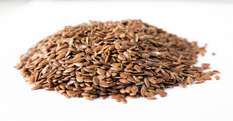 Hill of flax seeds on a white background.