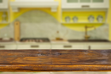A wooden board on the background of the kitchen. An empty product board. Sharpness in the foreground. Empty space for goods.