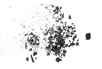 Small pieces of charcoal dust on white background, top view.