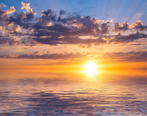 Beautiful sunrise with clouds of different colors against the blue sky and sea.