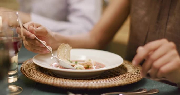 Woman hands detail while eating using fork during a romantic gourmet dinner or lunch.Wide shot. Friends italian trip in Umbria.4k slow motion