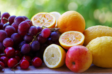 citric fruits, cherrys and grapes on table