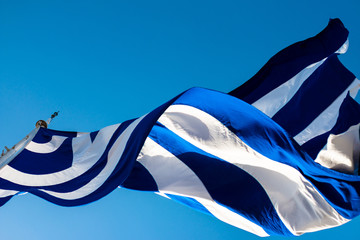 Griechische Fahne weht im Wind bei strahlend blauem Himmel