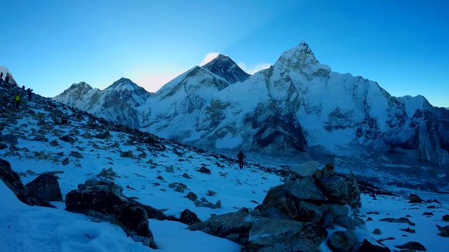 4k time lapse. Hikers climbs the slopes of Kala Patthar before dawn. Mount Everest and Mount Nuptse are visible in the background. Travel, adventure, hiking and climbing concept.