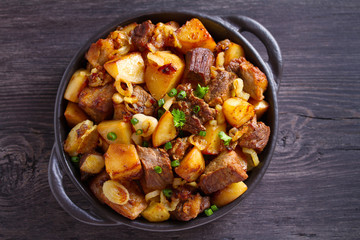 Tasty food: succulent beef with fried potatoes, onion and garlic. Country-style roasted potatoes with meat