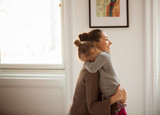 Side view of mother embracing daughter at home