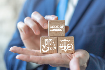 Code of conduct business concept on wooden blocks in businessman hands. Ethics and respect in...