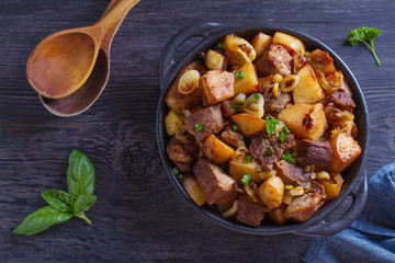 Tasty food: succulent beef with fried potatoes, onion and garlic. Country-style roasted potatoes with meat