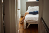Low section of woman lying on bed at home seen through doorway