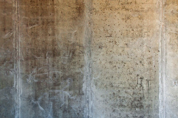 grunge background: rough concrete wall with cracks and dents, traces of formwork