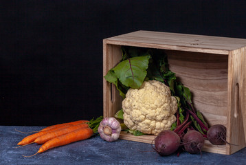 Composition of vegetables in wooden box. Organic food concept. 