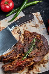 Tomahawk steak with vegetables and a knife on the table. Grilled meat with grilled vegetables and...
