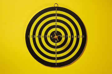 Yellow arrow dart hitting the center of the target dartboard