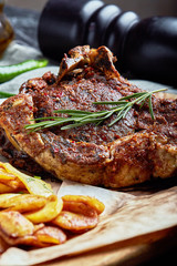 Tomahawk steak with vegetables and a knife on the table. Grilled meat with grilled vegetables and fresh vegetables on the table.