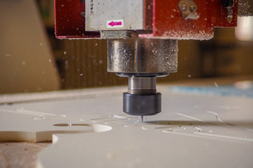 CNC cutter machine in action, cuting off plastic material