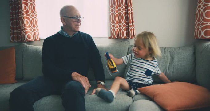 Toddler and grandfather playing with toy helicopter