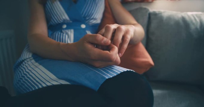 Close up on hands of young woman by window