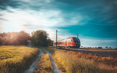 Train à grande vitesse se déplaçant dans la nature au coucher du soleil