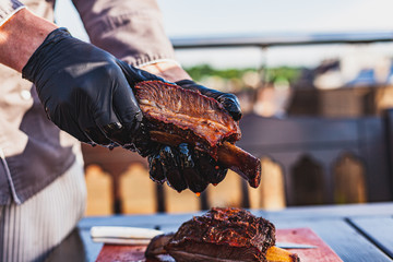 Chef holding cutted juicy slow cooked meat in hands