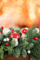 Beautiful festive arrangement of fresh spruce with ball toys in a rustic wooden box. Christmas mood. Bokeh of Garland lights on background.