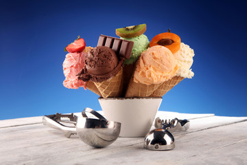 ice cream scoops of different colors and flavours with berries, nuts and fruits decoration on white background