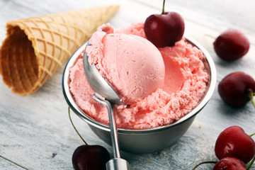 Cherry and vanilla ice cream scoop with fresh cherries and mint on a rustic background