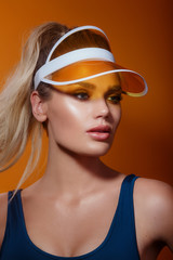 close-up portrait of a beautiful young woman wearing yellow plastic visor.