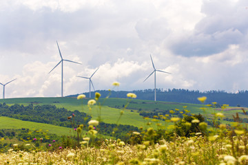 Wind turbines on beautiful sunny summer autumn mountain landsape.