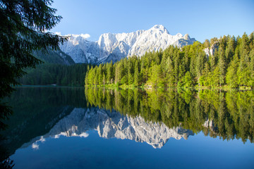 Beautiful morning scene with alpine peaks reflecting in tranquil mountain lake