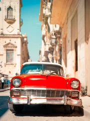 Tuinposter Classic red car on a narrow street in Old Havana © kmiragaya