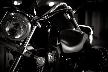  Black and white vintage photo of chopper bike details, chromed, with soft light and reflections, with side leather bags. Motorcycle wallpaper, background © Dawid G