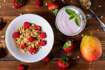 Strawberry smoothie with granola berries and mango table top view
