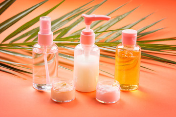 Generic beauty products on orange coral background. Summer travel kit or sun protection concept.