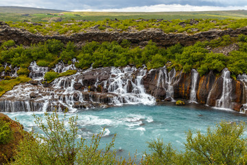 Hraunfossar waterfall powerful streams falling into Hvita river turquoise waters, Husafell, Western Iceland
