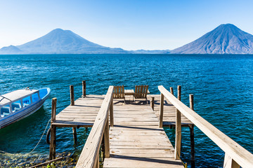 View from wooden jetty across Lake Atitlan to Atitlan, Toliman & San Pedro volcanoes in Guatemalan highlands, Central America