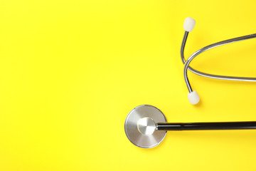 Stethoscope with space for text on color background, top view. Medical tool