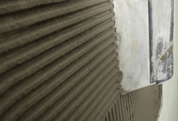 Spreading concrete on wall with spatula, closeup. Space for text