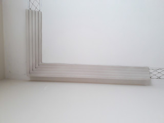 Installation of mouldings on the ceiling of the refurbished room. Fragment of molding, top view of corner placement. Home Improvements