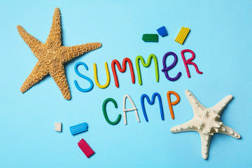 Flat lay composition with text SUMMER CAMP made of modelling clay on color background