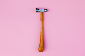 Jewelry hammer (tools, instruments) for the repair of jewelry on pink background. Fashion top view