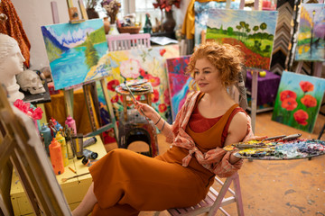 Promising artist sitting and looking at her picture