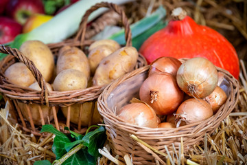 Onions and potatoes in wicker basket . Beautiful background for harvest festival